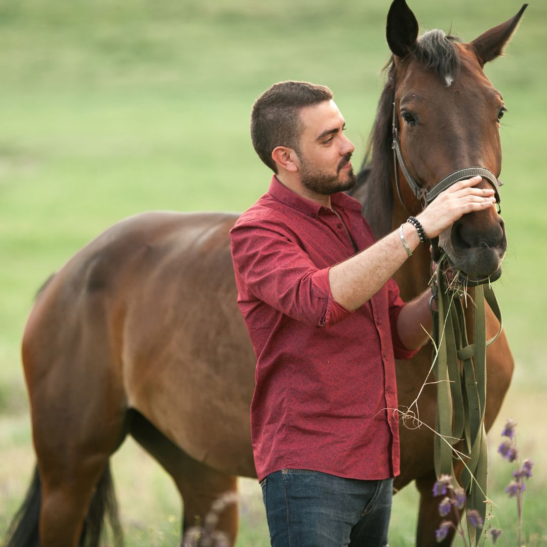 A man standing next to a horse