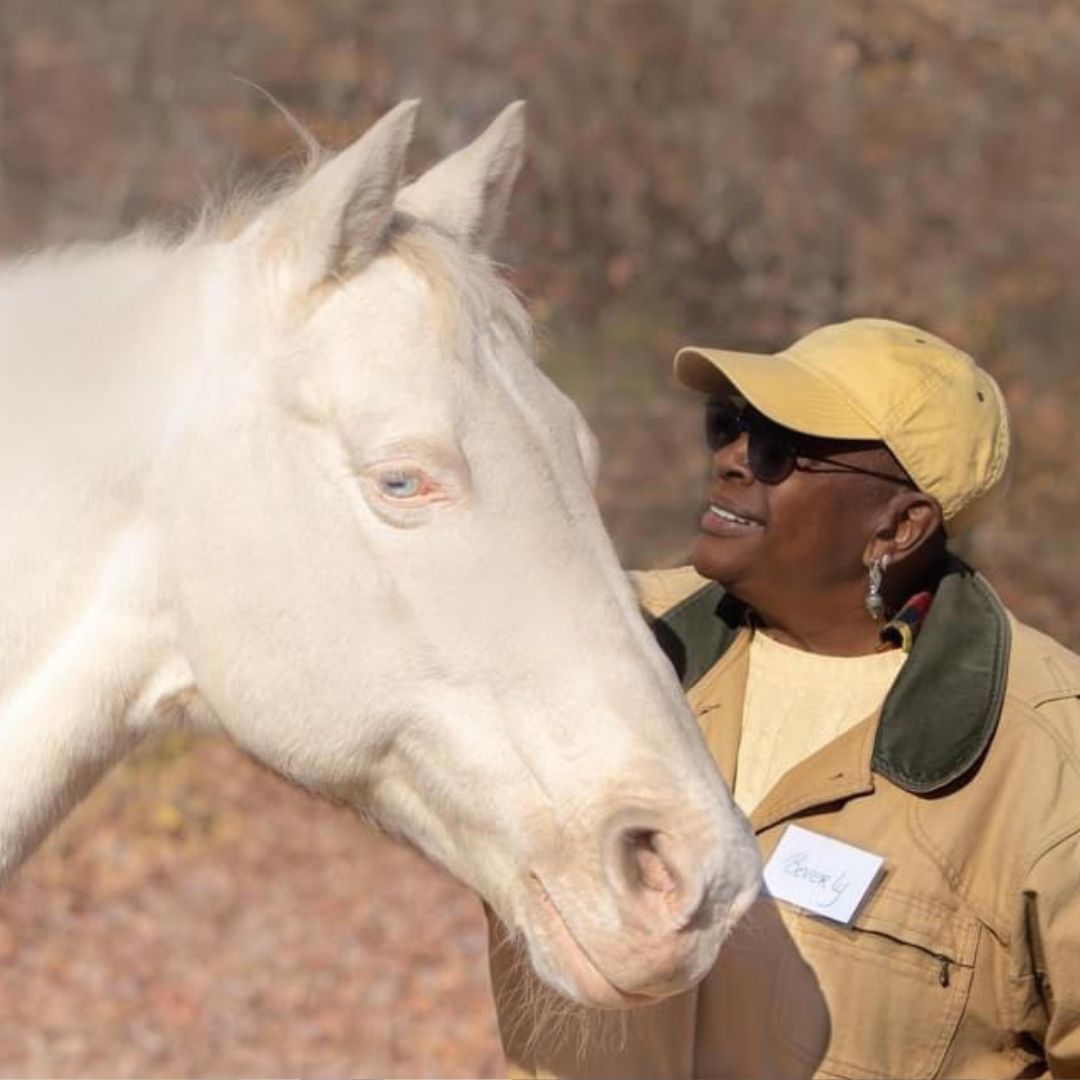 A woman standing next to a horse