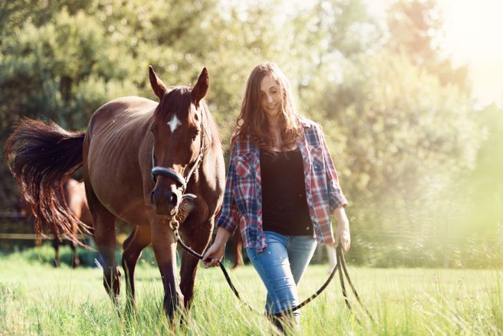 a woman walking wiht a horse