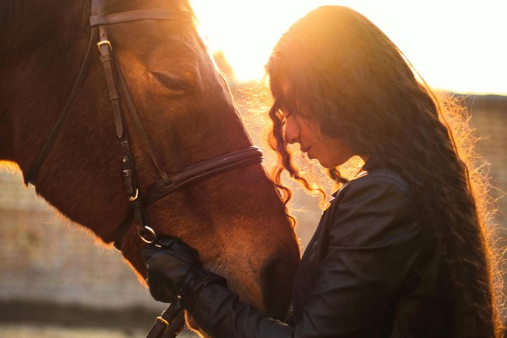 a woman embracing a horse in front of her