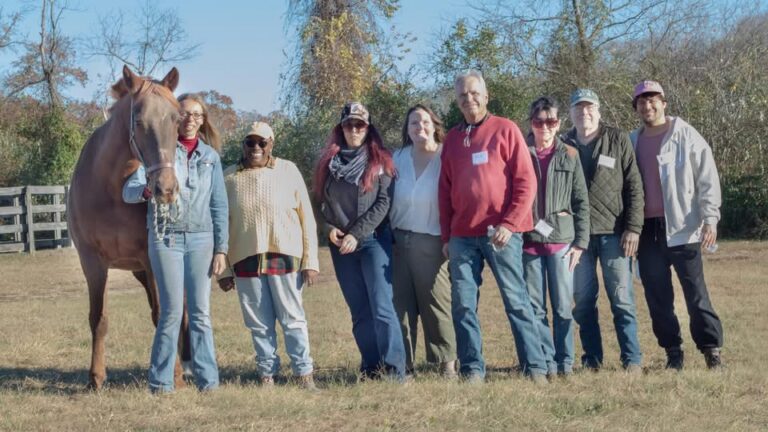 A group of people with a horse posing for a photo